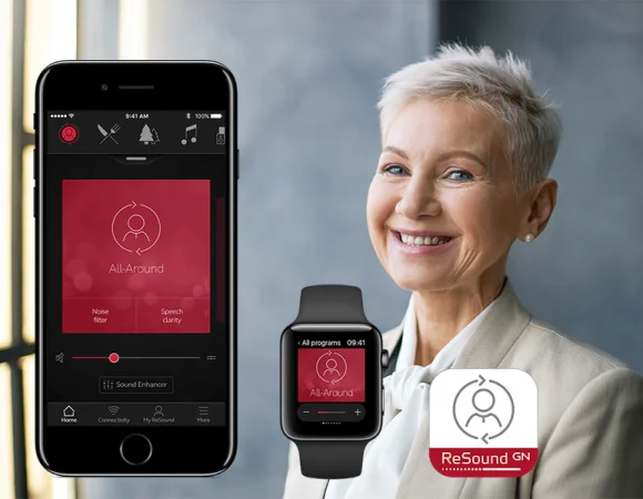 Frau mit der Resound GN App auf ihrem Smartphone und ihrer Smartwatch, die die All-Around Hörgerätefunktion zeigt.